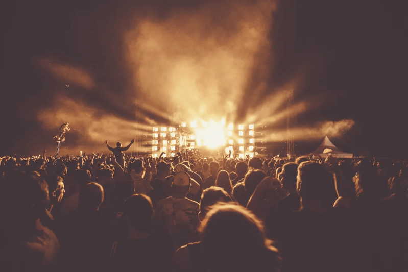 A stage in front of a packed crowd at night time