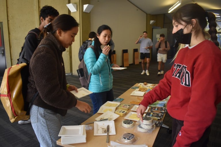 Students gathered around a table taste-testing cheese.