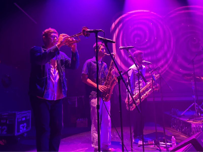 Three members of The Dip belonging to the horns section perform on stage