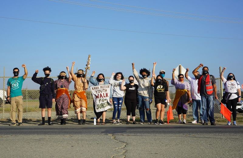 Protestors stand along the road with their fists raised at The Amah Mutsun Tribal Band's Youth Walk for Juristac event.