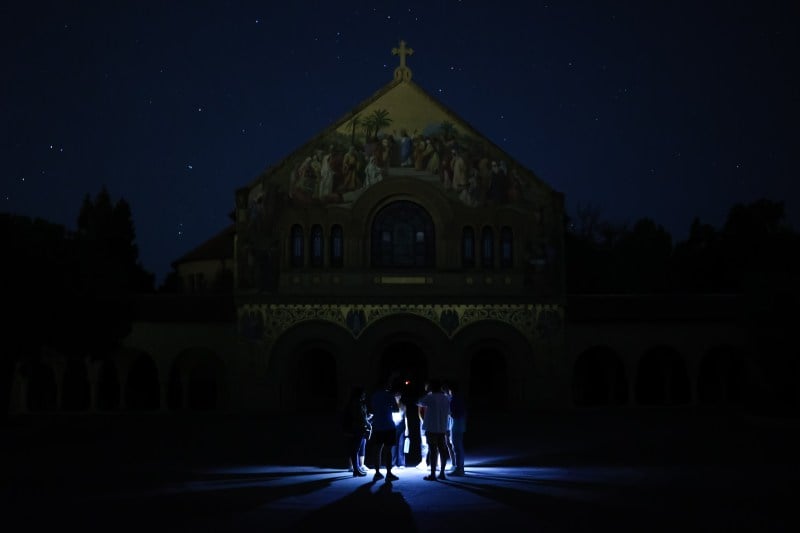 picture of dark memorial church with students standing in the middle with flashlights