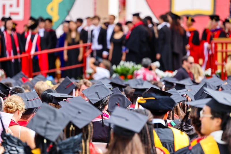 A close-up of graduation caps among the crowd of graduates