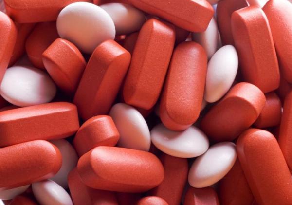 A zoomed in photo of red and white pills