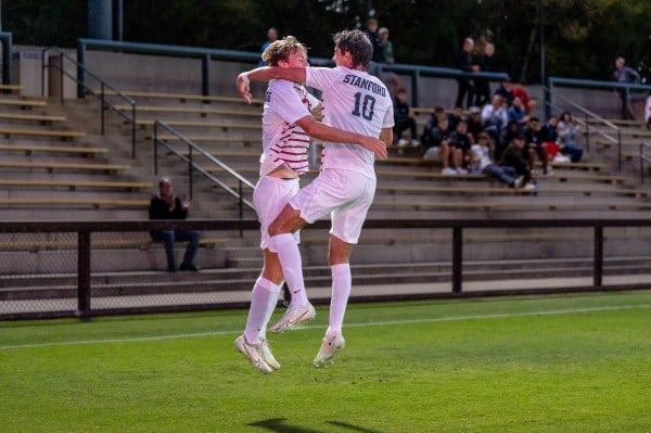 Two soccer players jump and embrace in the air