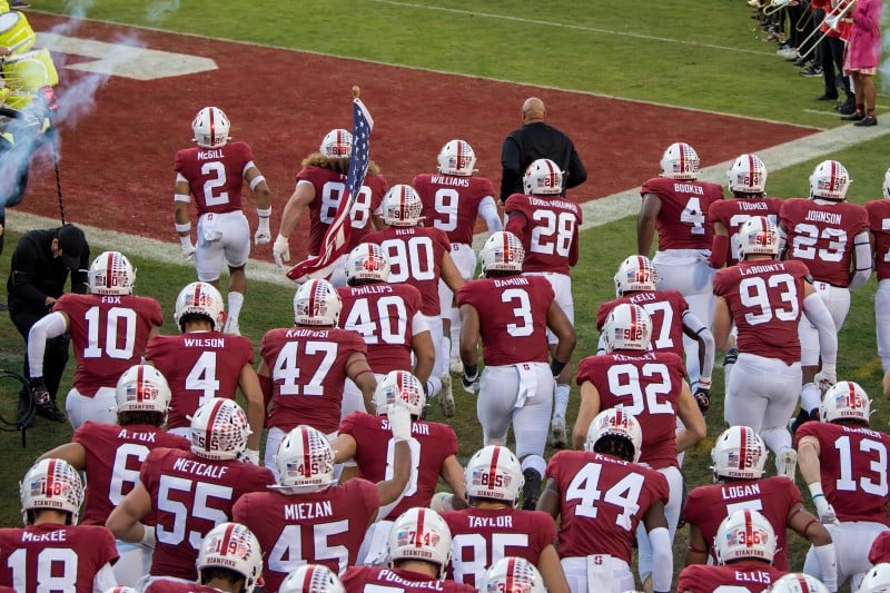 The Stanford football team runs onto the field