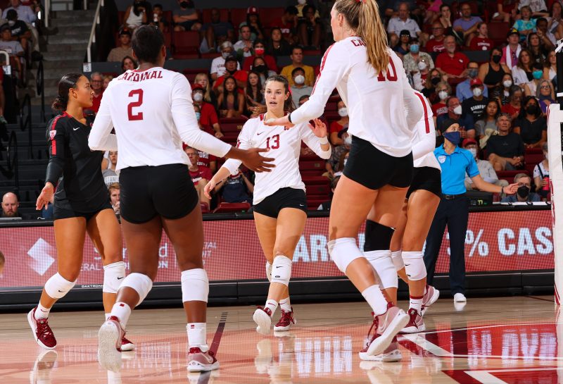 Stanford women's volleyball players celebrate after a point, Elia Rubin is in the center.