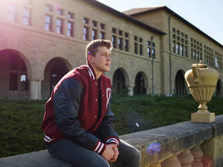 Sam sitting on a ledge in front of a building