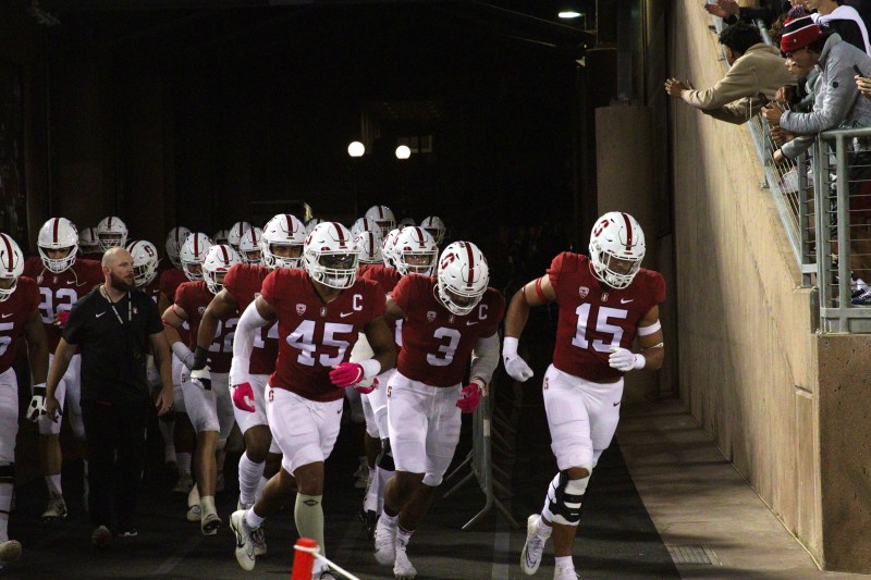Stanford football players run out of the tunnel onto the field