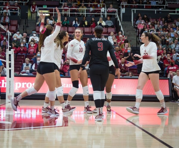 The women's volleyball team celebrates during a game.