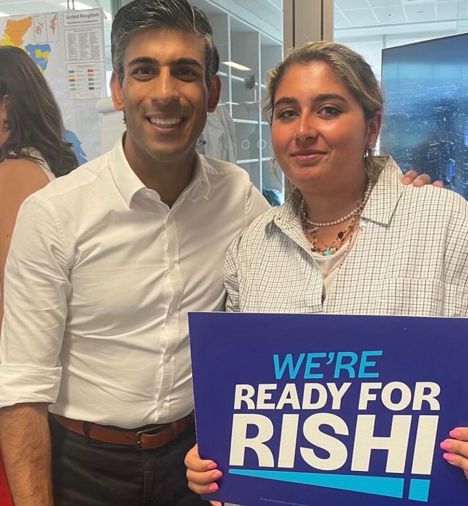 Romy McCarthy '25 poses with Rishi Sunak holding a blue sign that reads "We're Ready for Rishi" 