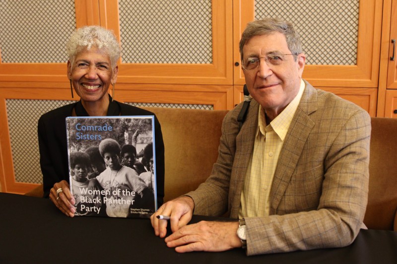 Ericka Huggins holds a copy of "Comrade Sisters" book and Stephen Shames sits on the left.