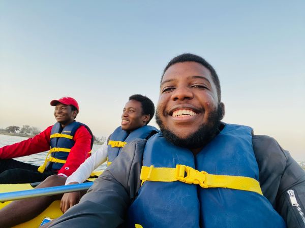 Nyandoro, Caitano, and Mpala on a kayak wearing life vests