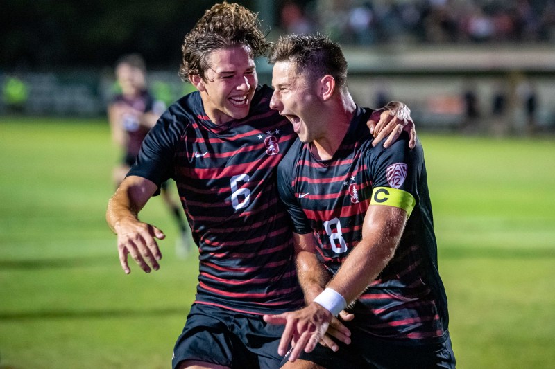 Two soccer players celebrate a goal.