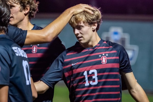 A Stanford soccer player places his hand on on Shane de Flores' head