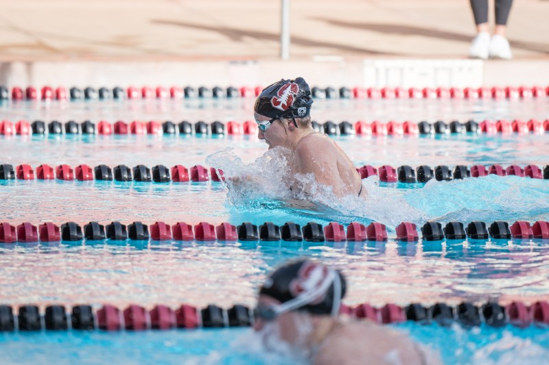 A swimmer is shown mid-stroke in the water.