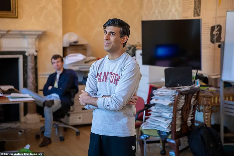 Rishi Sunak stands in a grey Stanford sweater during NYT photoshoot