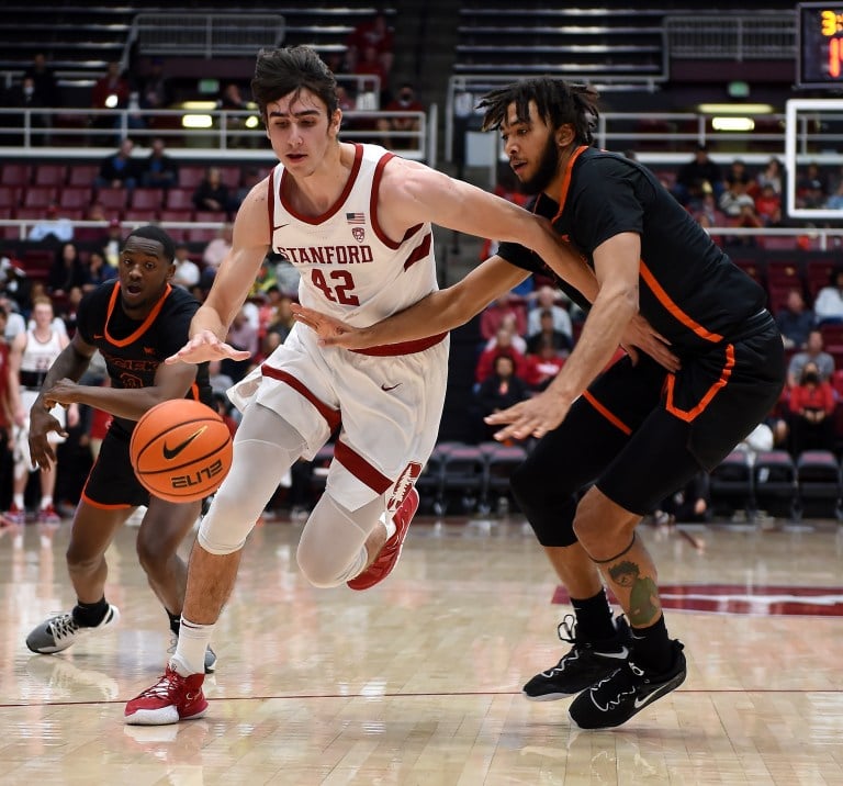 A basketball player drives by his defender