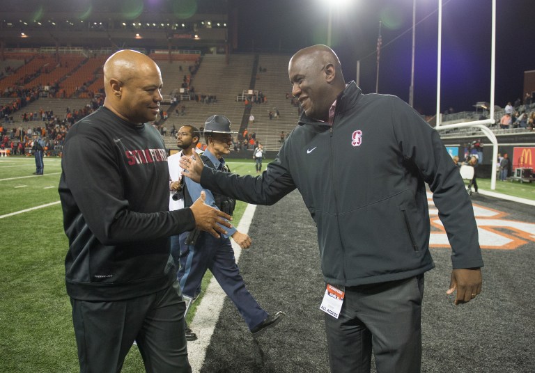 David Shaw shakes hands with Bernard Muir on the football field