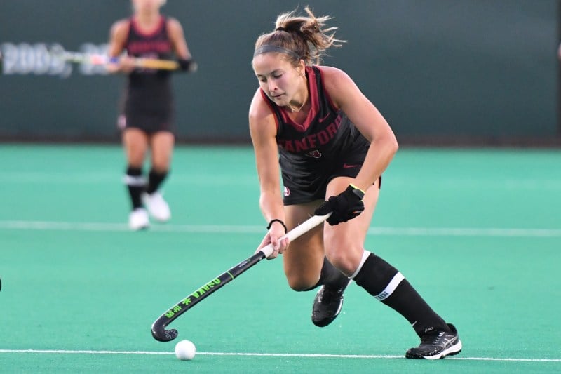 A field hockey player chases after the ball