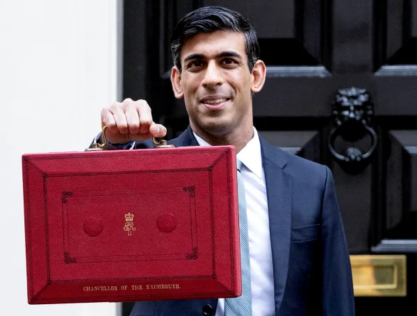 Rishi Sunak holding up a red box with royal insignias