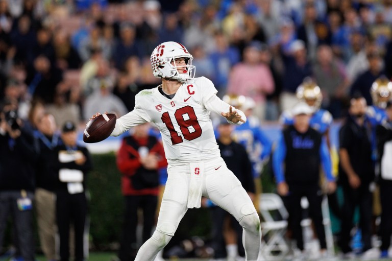 A football quarterback winds his arm back to throw