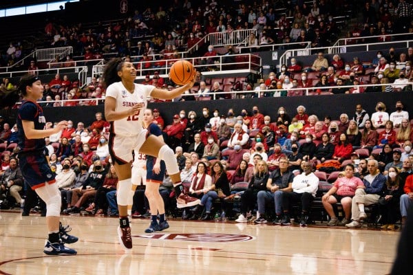 A women's basketball player goes up for a left-handed layup