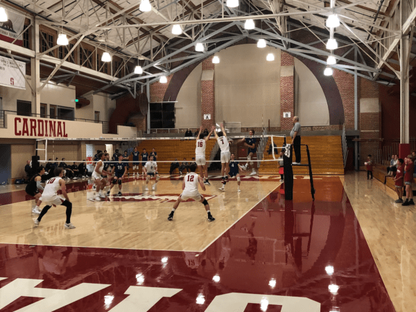 two male volleyball players go up for a block