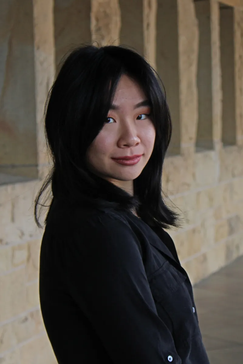 Portrait of Ana Chen in front of bricks wearing a black top