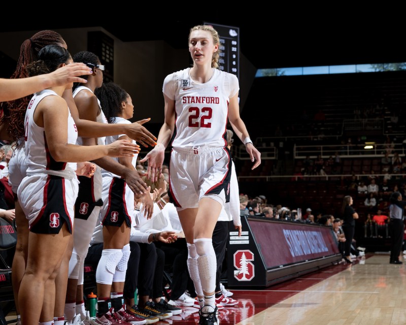 A women's basketball player high fives her teammates