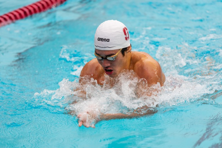 A swimmer emerges from the water