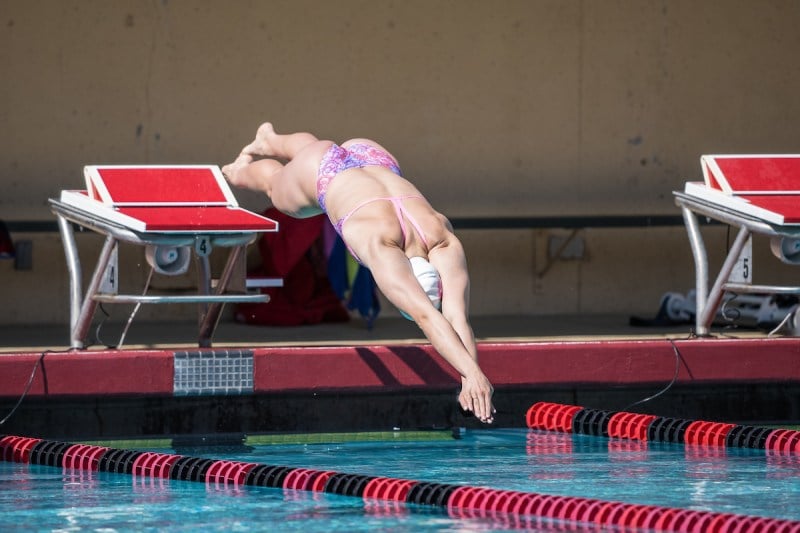 A swimmer in mid-air diving into the pool