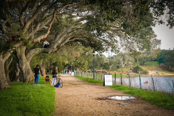 Students lounge near and in a sunny Lake Lagunita when it was filled in 2023. With spring on the horizon, the clocks jumped forward this weekend to provide an extra hour of sunlight. (Photo: ANANYA NAVALE/The Stanford Daily)