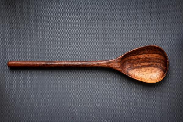 A wooden spoon against a blank gray background.