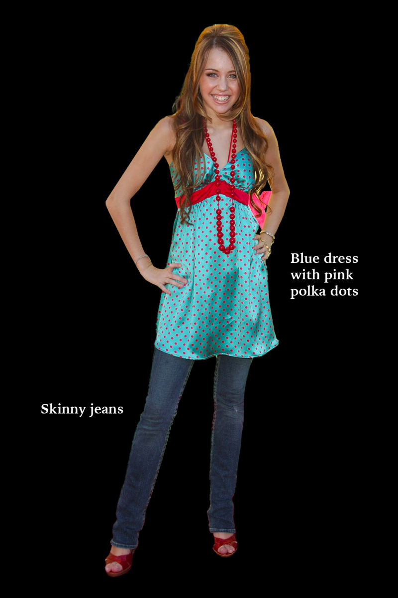 against a black background, a photo of a young person with light skin and long brown hair. they are wearing a blue dress with pink polka dots over a pair of blue skinny jeans, complete with red heeled sandals.