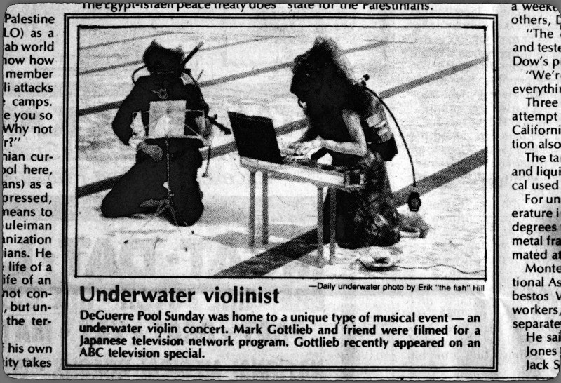Two musicians play underwater in a newspaper photo.