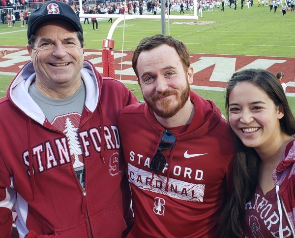 Three people in Stanford clothes at a football game.