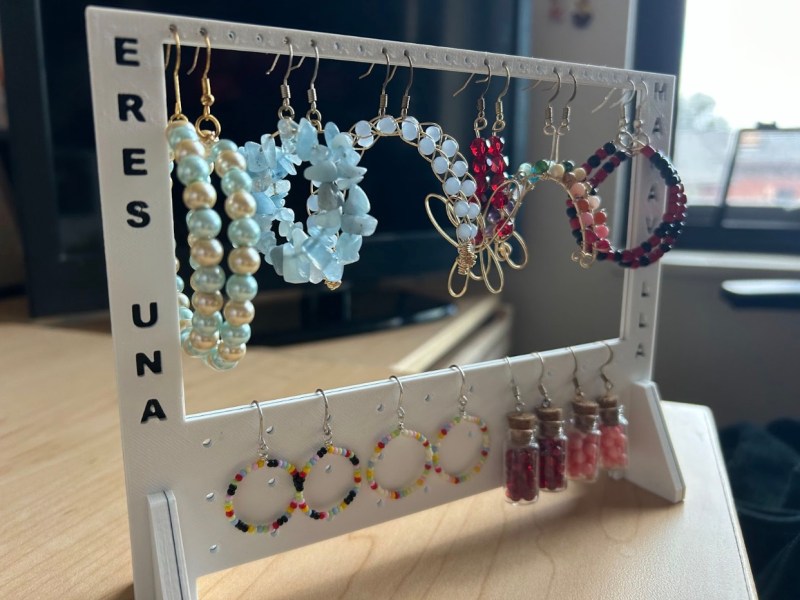 White earrings rack displaying earrings made by Empowered Codes and Moonphase.