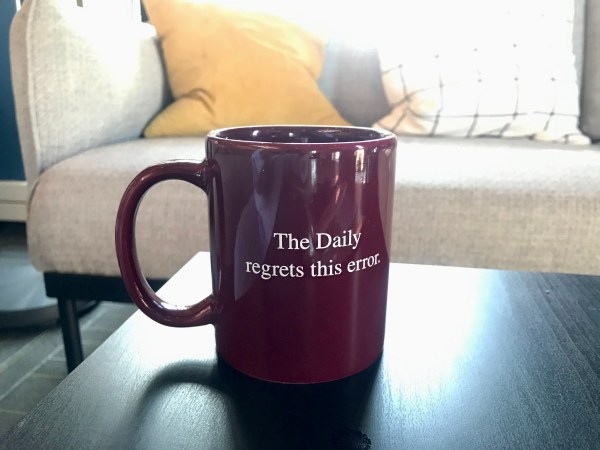Red mug with white text reading "The Daily regrets this error."