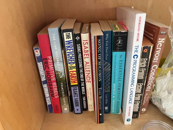 A collection of worn books nestled within a bookshelf.