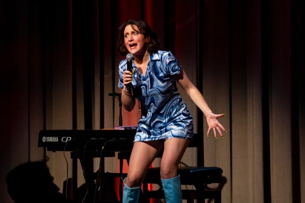 Emily Wilson performs into a microphone during her comedy show.