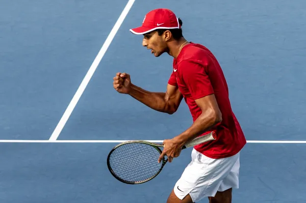 Samir Banerjee clenches his fist in celebration during a tennis match.