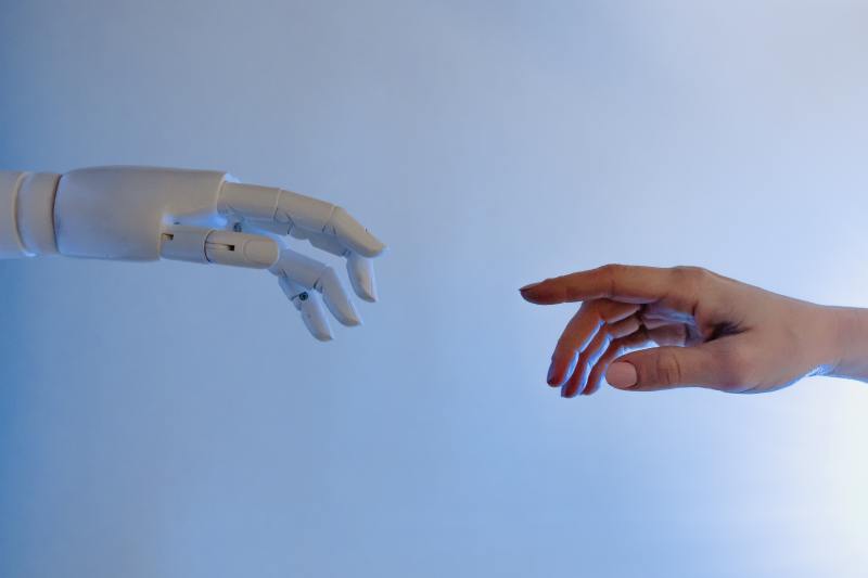 Robot hand reaching toward human hand.