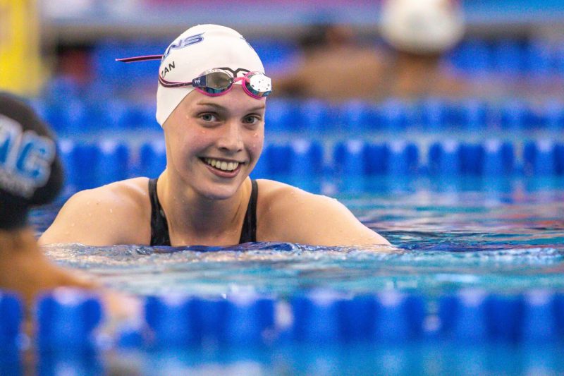 Claire Curzan smiling in the pool after a race.