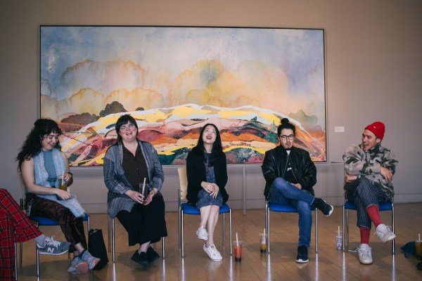 Featured artists at the Cantor sitting in front of a painting.