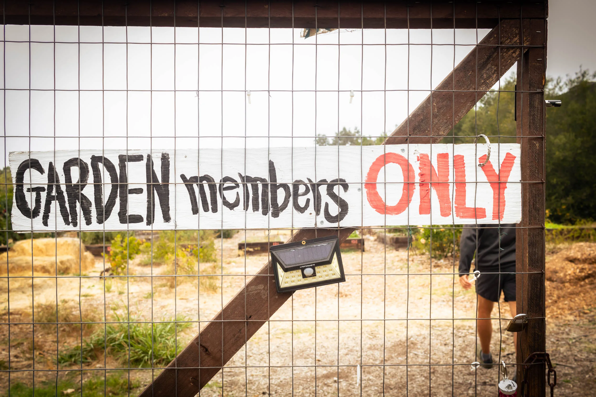 Sign on a gate that reads "garden members only"