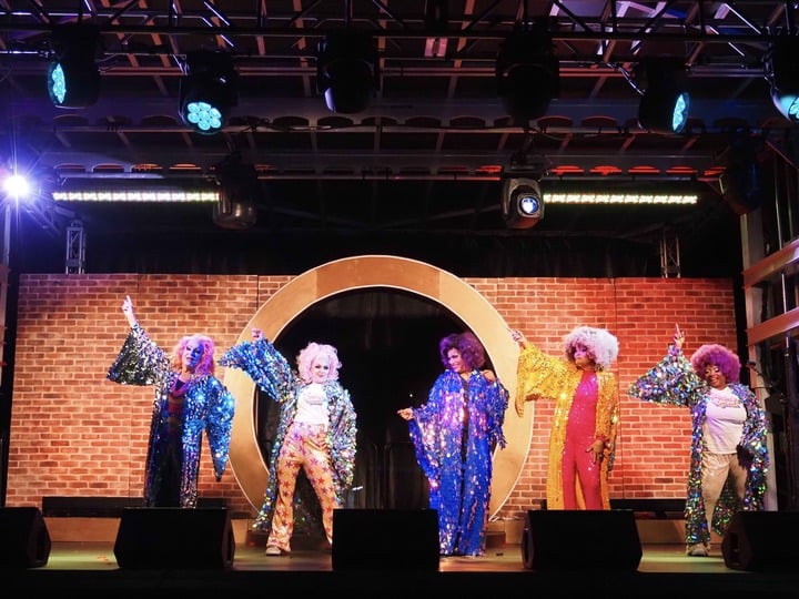 Mona Hicks, Persis Drell, Susie Brubaker Cole, Jeanette Smith-Laws and Shirley Everett wear big, colorful wigs, dramatic makeup and shimmering, sequined robes while dancing to ABBA.