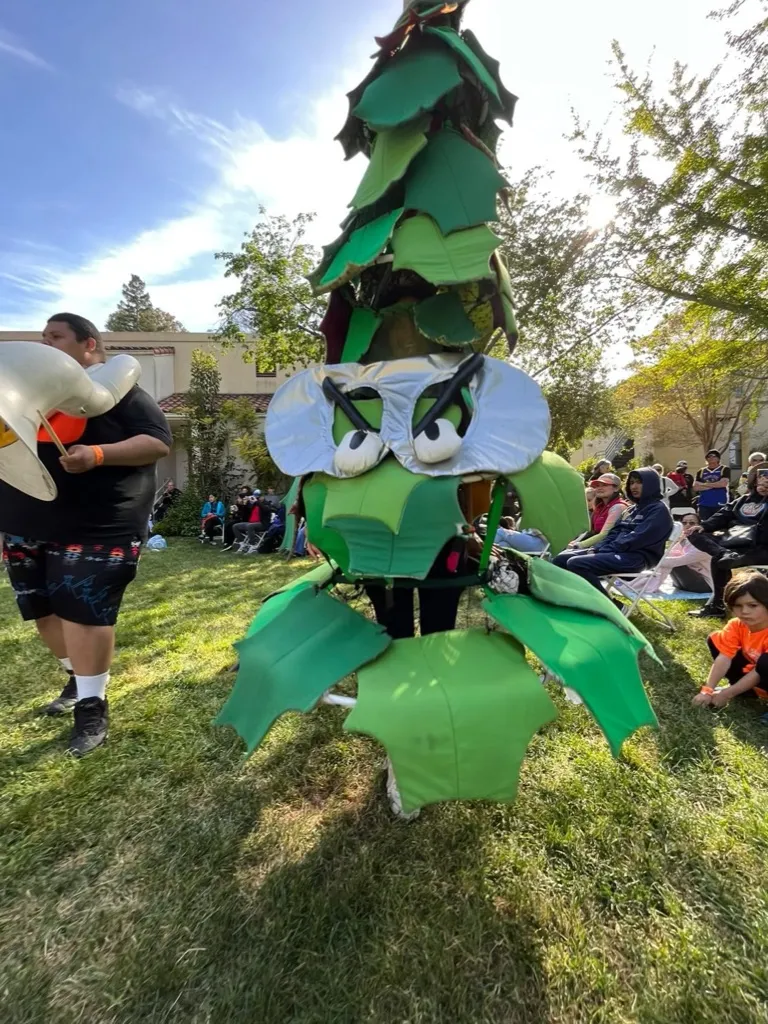 a costume of a tree with green leaves and wide, angry eyes