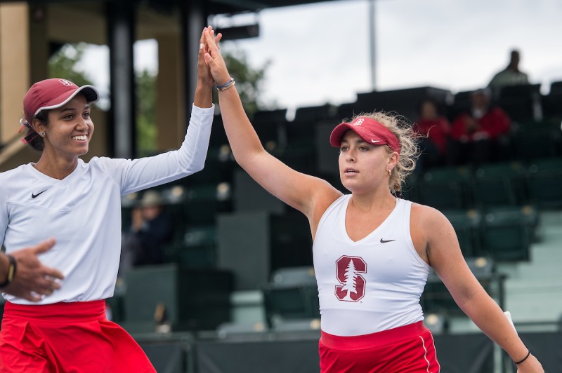 Two Stanford tennis players high five each other