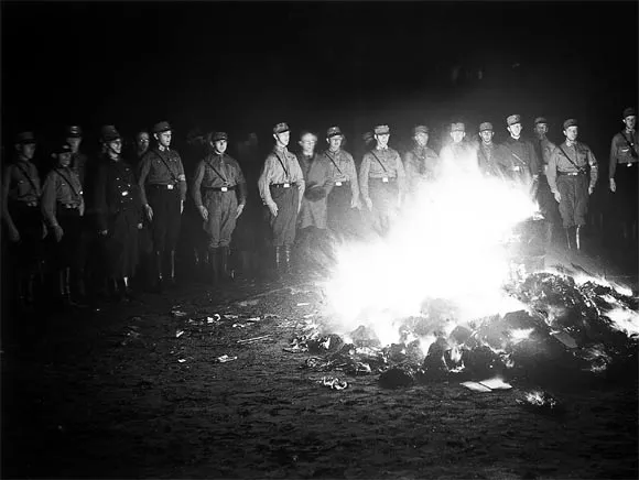 Nazi soldiers stand in front of a fire