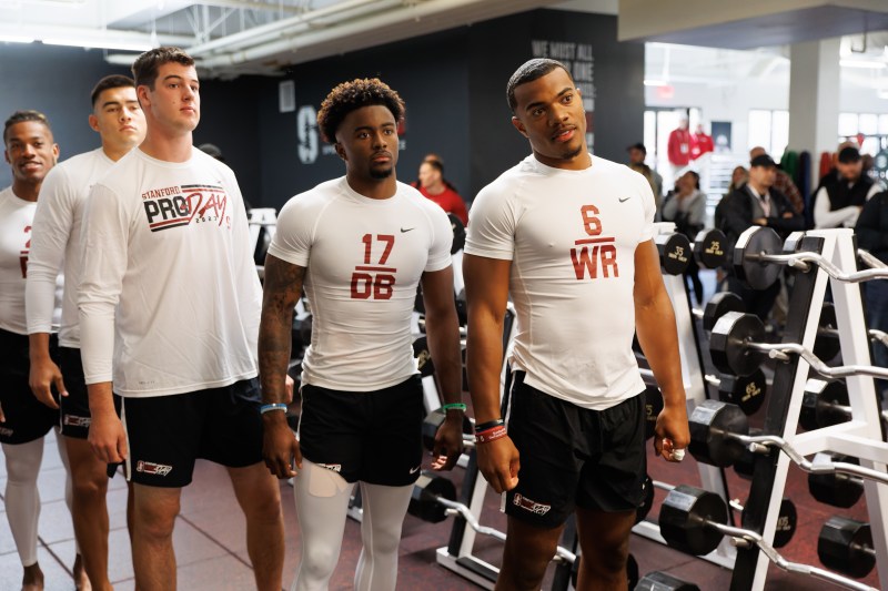 Players line up on pro day, wearing shirts identifying them by number and position.